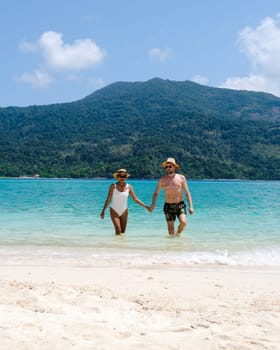 Couple on the beach of Koh Lipe Island Thailand, a tropical Island with a blue ocean and white soft sand. Ko Lipe Island Thailand on a sunny day