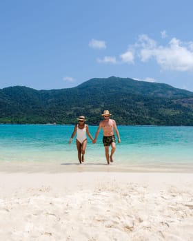 Couple on the beach of Koh Lipe Island Thailand, a tropical Island with a blue ocean and white soft sand. Ko Lipe Island Thailand on a sunny day