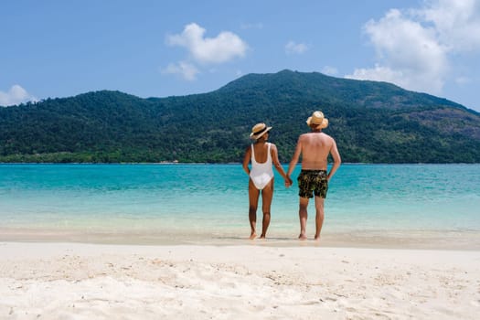 Couple on the beach of Koh Lipe Island Thailand, a tropical Island with a blue ocean and white soft sand. Ko Lipe Island Thailand