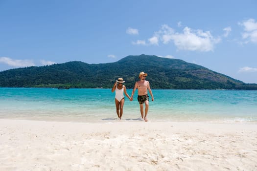 Couple of men and women on the beach of Koh Lipe Island Thailand, a tropical Island with a blue ocean and white soft sand. Ko Lipe Island Thailand