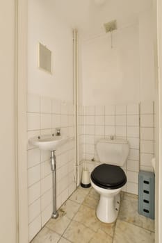 a bathroom with a toilet, sink and trash can in the corner next to the shower stall on the floor