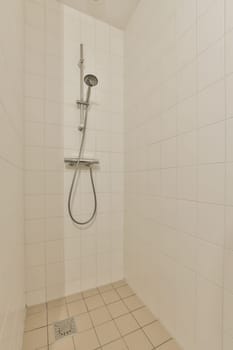 a white tiled bathroom with a shower head and hand rail in the wall is made out of ceramic tiles on the floor