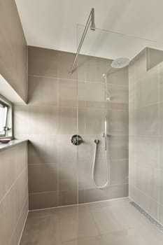 a walk in shower with tiled walls and white tiles on the wall, there is a large mirror above it