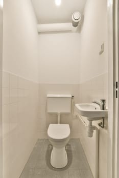 a toilet and sink in a small white bathroom with tile flooring on the walls, there is a mirror above it