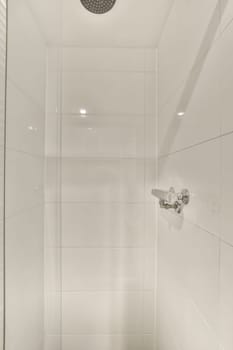 a shower with white tiles on the walls and floor, as well in this image is taken from above it