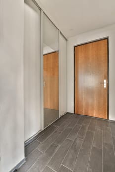 an empty room with wood doors and tile flooring on the right side of the room, there is a wooden door in the