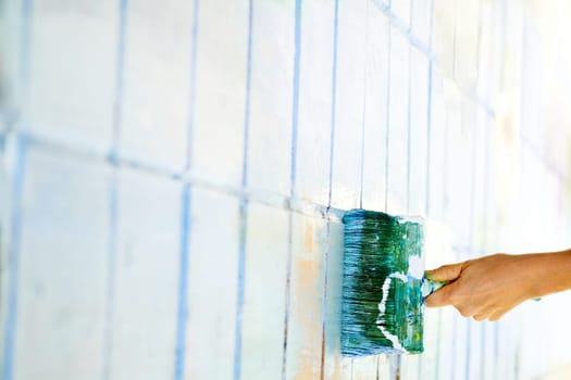 an implement with a handle, consisting of bristles, hair, or wire set into a block, used for cleaning, applying a liquid to a surface. Roller painting white wall surface with green emerald paint