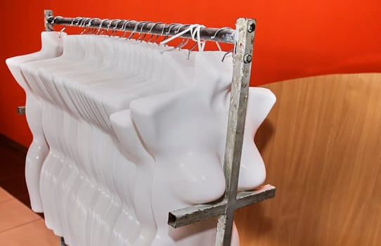 Female mannequins without clothes hang on a hanger. Imitation of the female body.