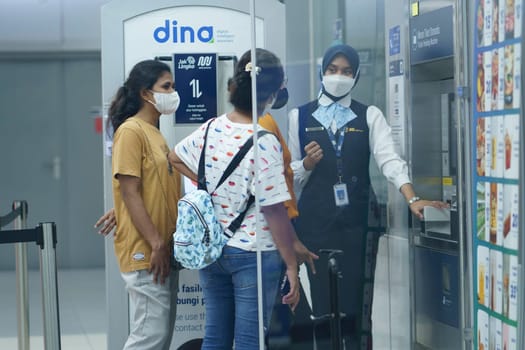 An officer is helping people at the ticket machine at the MRT Station, Jakarta, Indonesia. April 20, 2023. Publice service photography.