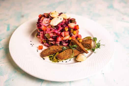 close-up salad vinaigrette with black bread on a plate.