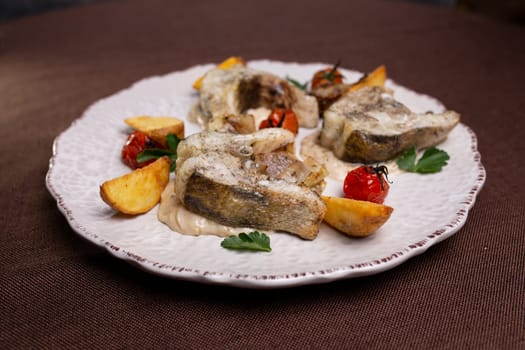 fish dishes. pieces of fish with potatoes on a plate.