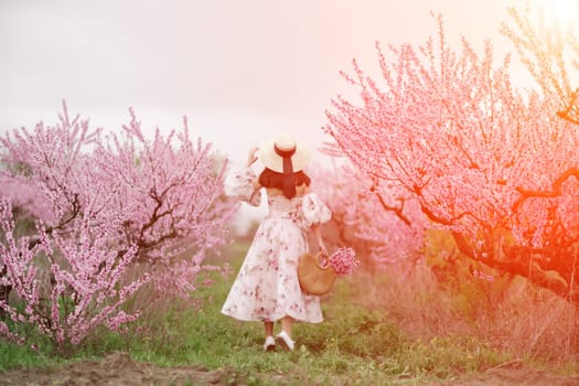 Against the backdrop of a picturesque peach orchard, a woman in a long dress and hat enjoys a peaceful walk in the park, surrounded by the beauty of nature