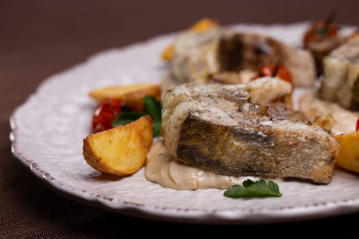 fish dishes. pieces of fish with potatoes on a plate.