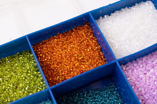 Colorful beads in containers close up, handicrafts, macrophoto