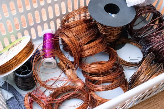 Copper wire coils in a plastic basket close up