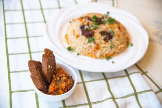 pilaf and salad, black bread on the table.