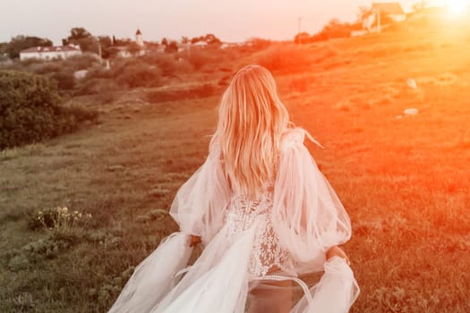 beautiful young bride in a field at sunset.