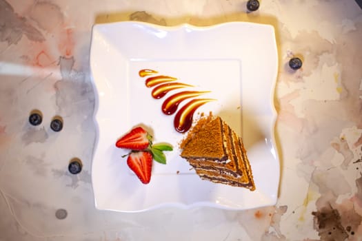 layered honey cake on a white plate top view.