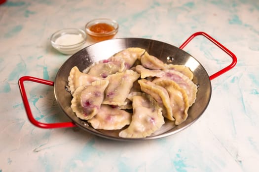 juicy dumplings with berries and jam in a cafe.