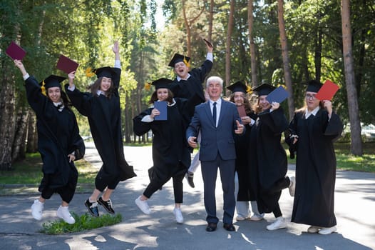 A university professor and seven robed graduates are jumping outdoors