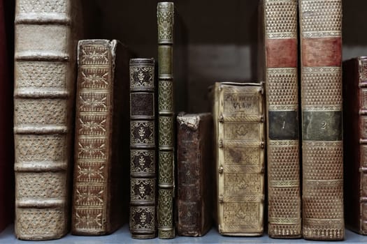 Old worn books on a shelf in the library's archives