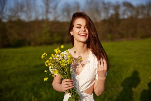 Beautiful woman in a white dress with a bouquet of yellow wildflowers walking in a field . High quality photo