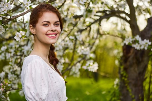 beautiful woman standing near blossoming bush. High quality photo