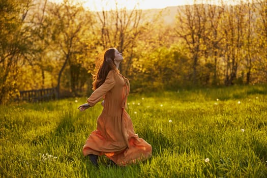 a joyful woman runs through a green field during the sunset enjoying a warm summer day and nature. Horizontal photography in nature. High quality photo