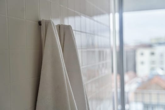 Two white towels hanging in the hotel shower room. High quality photo