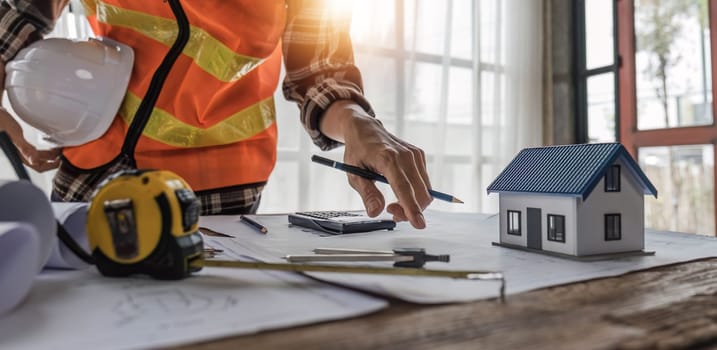 Close up of civil male engineer asian working on blueprint architectural project at construction site at desk in office...