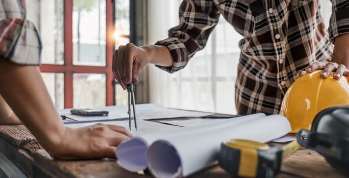 engineer people meeting working and pointing at a drawings in office for discussing. Engineering tools and construction concept...