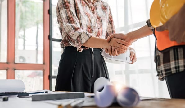 Architect and engineer construction workers shaking hands while working for teamwork and cooperation concept after finish an agreement in the office construction site, success collaboration concept..