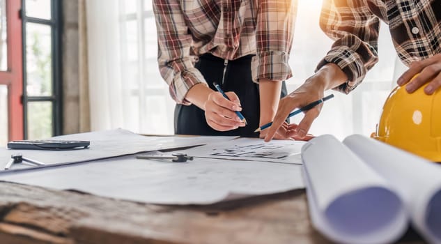 engineer people meeting working and pointing at a drawings in office for discussing. Engineering tools and construction concept...