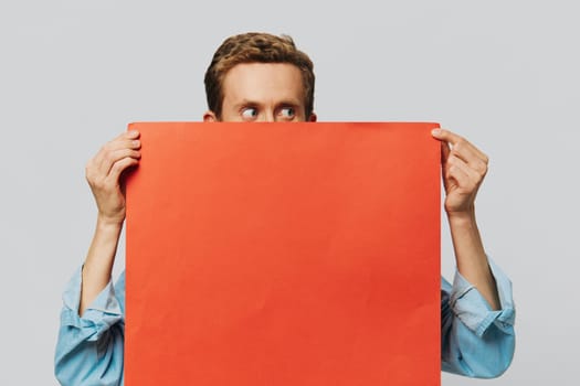 Portrait of an adult male on a gray background with a red piece of paper for your design and text, layout, copy space, space for text. High quality photo