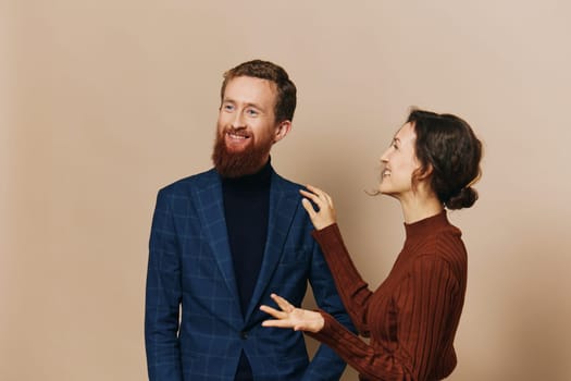 Man and woman couple in a relationship smile and interaction on a beige background in a real relationship between people. High quality photo