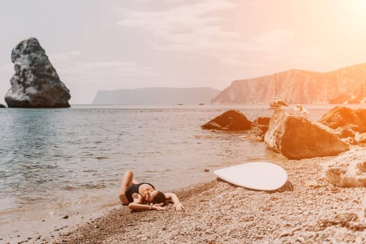 Woman travel sea. Young Happy woman in a long red dress posing on a beach near the sea on background of volcanic rocks, like in Iceland, sharing travel adventure journey