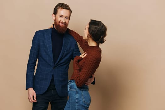 Man and woman couple in a relationship smile and interaction on a beige background in a real relationship between people. High quality photo