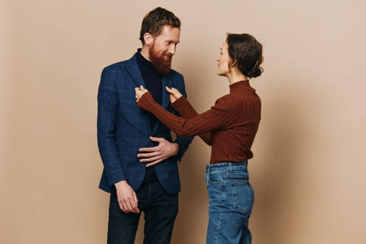 Man and woman couple in a relationship smile and interaction on a beige background in a real relationship between people. High quality photo