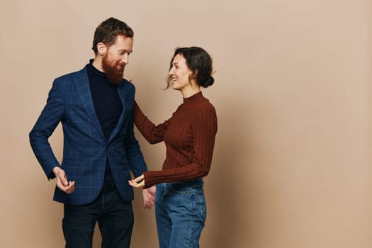 Man and woman couple in a relationship smile and interaction on a beige background in a real relationship between people. High quality photo