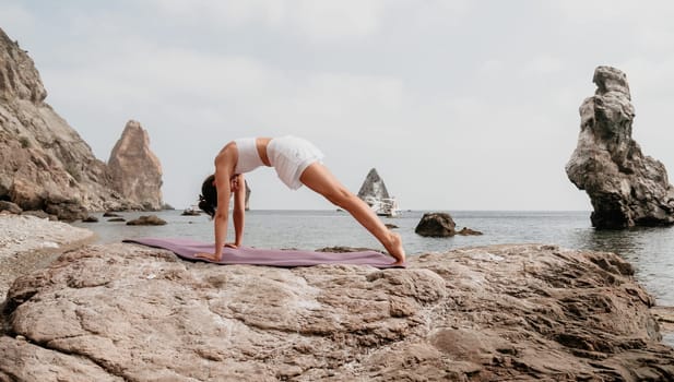 Fitness woman sea. Outdoor workout on yoga mat in park near to ocean beach. Female fitness pilates yoga routine concept. Healthy lifestyle. Happy fit woman exercising with rubber band in park.