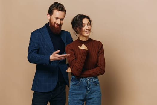 Man and woman couple in a relationship smile and interaction on a beige background in a real relationship between people. High quality photo