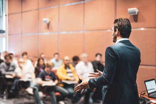 Speaker at Business Conference with Public Presentations. Audience at the conference hall. Entrepreneurship club. Rear view. Horisontal composition. Background blur.