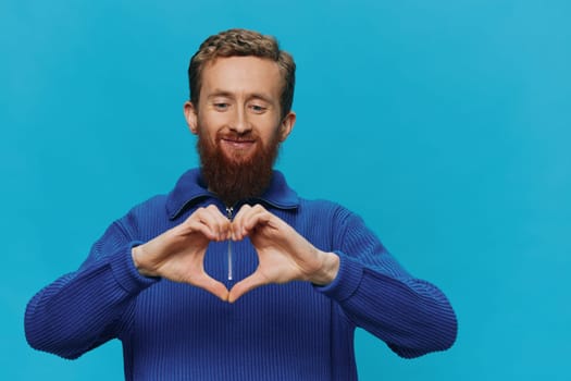 Portrait of a man in a sweater smile and happiness, hand signs and symbols, on a blue background. Lifestyle positive, copy place. High quality photo