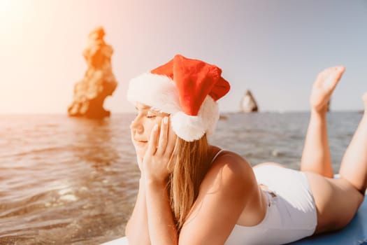 Close up shot of happy young caucasian woman looking at camera and smiling. Cute woman portrait in bikini posing on a volcanic rock high above the sea