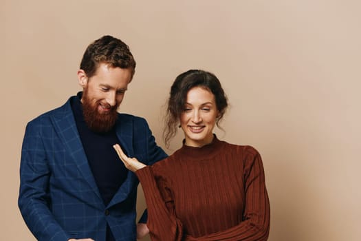 Man and woman couple in a relationship smile and interaction on a beige background in a real relationship between people. High quality photo