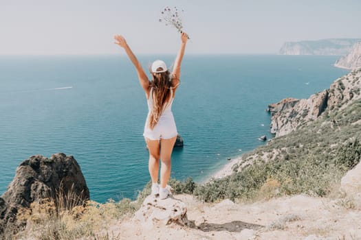 Woman travel sea. Young Happy woman in a long red dress posing on a beach near the sea on background of volcanic rocks, like in Iceland, sharing travel adventure journey