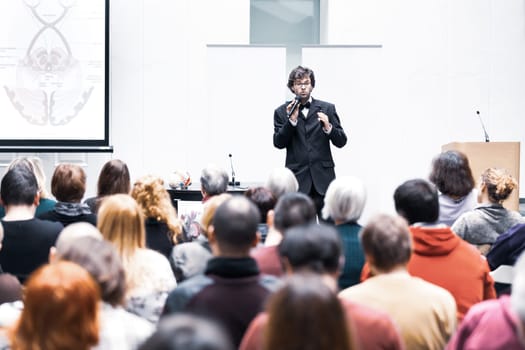 Speaker Giving a Talk at Business Meeting. Audience in the conference hall. Business and Entrepreneurship. Copy space on white board.