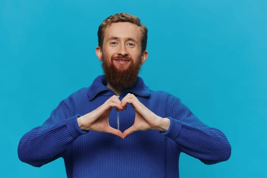 Portrait of a man in a sweater smile and happiness, hand signs and symbols, on a blue background. Lifestyle positive, copy place. High quality photo