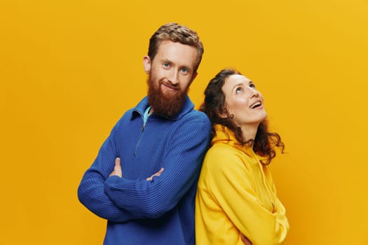 Man and woman couple smiling cheerfully and crooked with glasses, on yellow background, symbols signs and hand gestures, family shoot, newlyweds. High quality photo