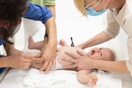 Baby beeing vaccinated by pediatrician in presence of his mother. Preventive vaccination against Diphtheria, whooping cough, tetanus, hepatitis, haemophilus influenzae, pneumococcus, poliomyelitis.